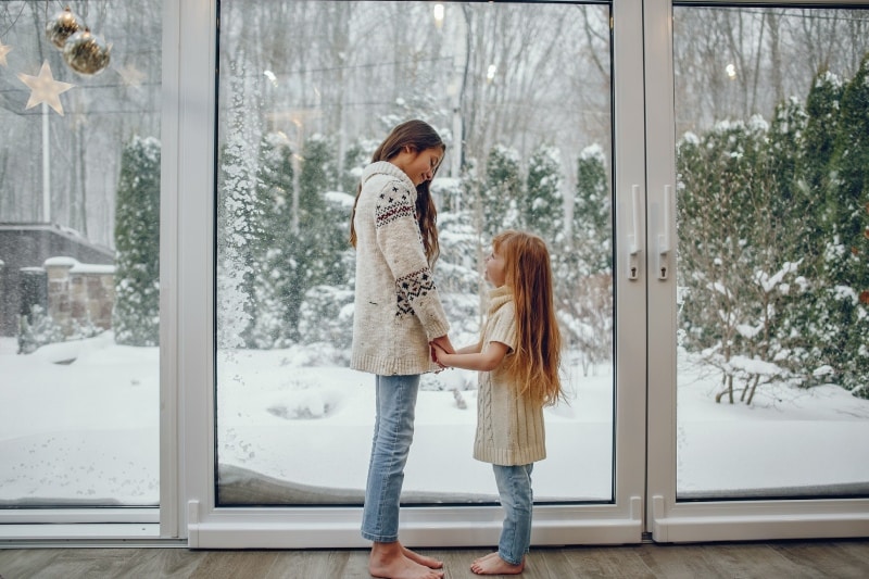 mujer y nina junto a ventana deslizante
