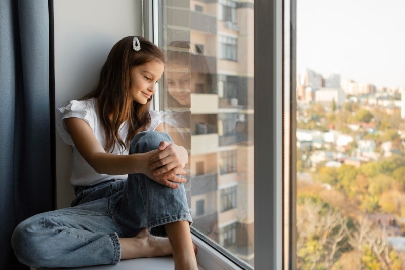nina mirando por la ventana